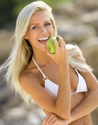 Ένα κορίτσι τρώει ένα μήλο για να χάσει 10 κιλά το μήνα